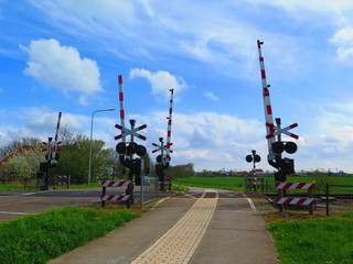 Red and white barriers at railway crossing
