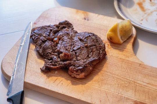 Medium rare Beef grilled with lemon slice on wood chopping block