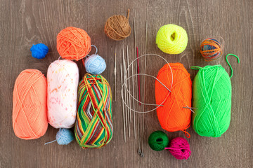 Balls of yarn and knitting needles different. Multicolored yarn, straight and circular knitting needles. View from above. Knitting as a kind of hobby and needlework.