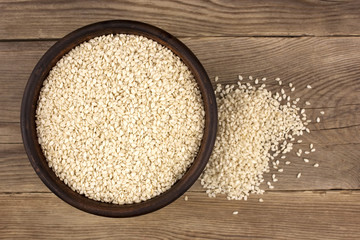 White sesame in a bowl on wooden background