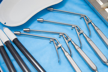 Ligators for the treatment of hemorrhoids made of stainless steel on blue medical tablecloths