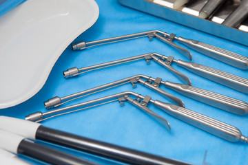 Ligators for the treatment of hemorrhoids made of stainless steel on blue medical tablecloths
