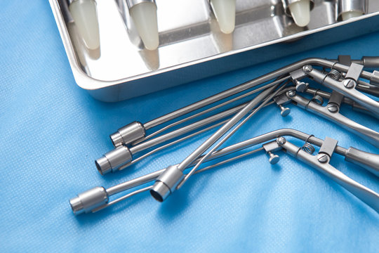 Anoscopes and ligators for the diagnosis and treatment of hemorrhoids made of stainless steel on a blue medical tablecloth