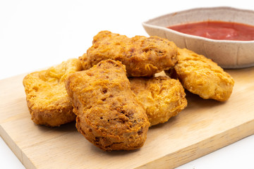 Close up of Chicken nuggets with ketchup on wooden tray
