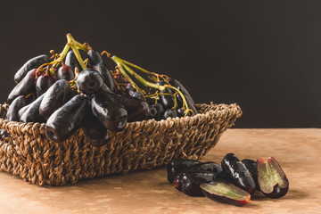 Black seedless moon drops grape or Witch fingers grape in basket with black background