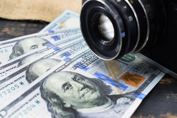 earnings in photography, a camera and money (dollars) are on the table