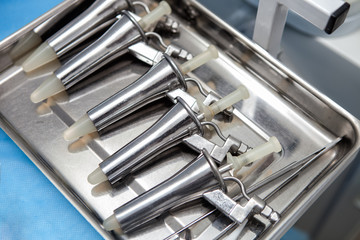 Anoscopes in a medical stainless steel tray on a blue medical tablecloth