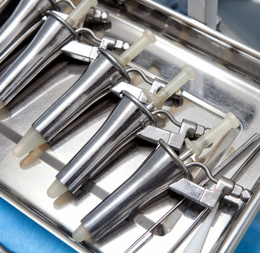 Anoscopes in a medical stainless steel tray on a blue medical tablecloth