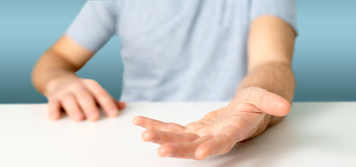 Empty holding hands of a young relaxed man over a desk