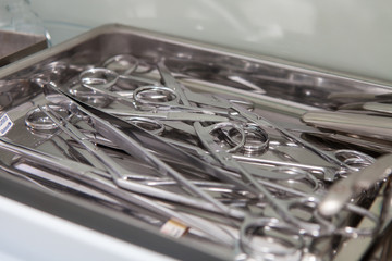 Medical scissors, tweezers and other tools in a stainless steel tray