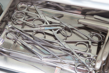 Medical scissors, tweezers and other tools in a stainless steel tray