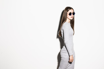 Fototapeta premium Fashion trendy brunette woman in dress and sunglasses posing in the isolated on white background