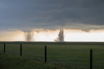 Twin tornadoes churning dirt on the high plains of Colorado.