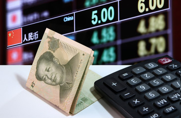 One yuan banknote of China and calculator on the white floor with digital board of currency exchange money background, the concept of finance.