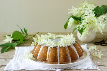 Lemon pie with a glaze of sugar and elderflower syrup, decorated with elderberry flowers. Rustic style.