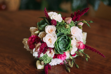 beautifully decorated wedding bouquet of roses lying on a wooden surface