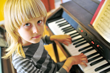 Fototapeta na wymiar Cute little boy playing electric piano