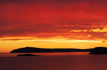 Obraz premium red sunset at the sea, red sun, fiery sky, sea ​​sunset