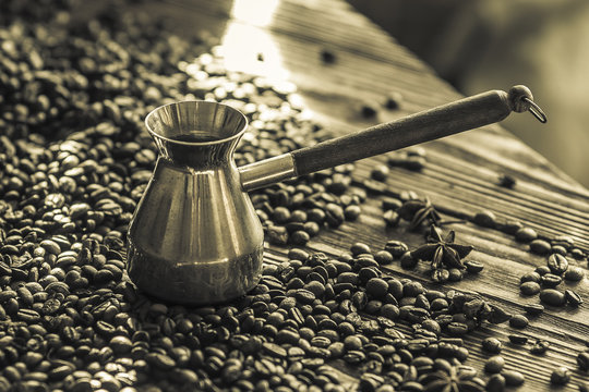 Jezve. Coffee beans. Wooden background.