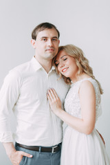 Fototapeta premium Beautiful couple in wedding photo shoot. Loft Studio in European style, bright and with large Windows. Loving people with happy faces. Bridal bouquet and stylish decorative.