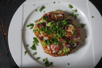 Mini pizza back from oven and waiting to be served on white plate background.