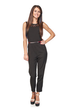 Happy woman in black jumpsuit standing relaxed smiling at camera, full length portrait