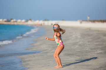 little girl  jumping on the beach on blue sea shore in summer vacation at the day time