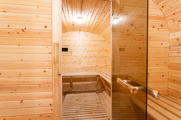 interior of sauna. rural mobile wooden bath in the form of a barrel in a pine forest