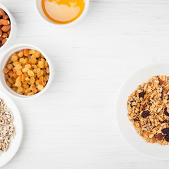 Healthy breakfast with granola. The bowls of granola and ingredients on the white wooden table. Top view with place for text.