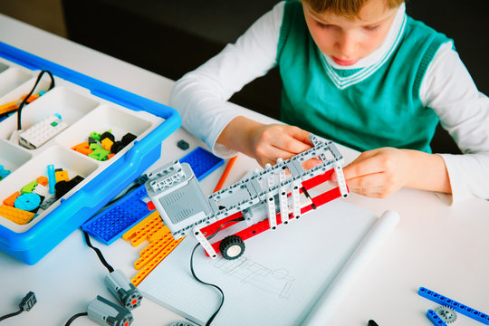 little boy building robot at robotic technology lesson