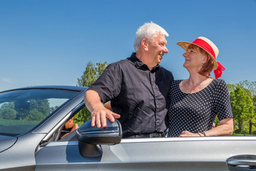 Older couple in a convertible car taking a break