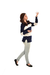 full length portrait of girl wearing striped blue and white jumper and jeans. standing pose on white studio background