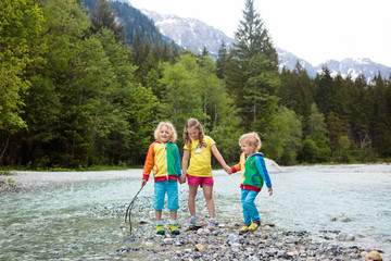 Obraz premium Child hiking in mountains. Kids at river shore.