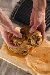 man sculpts hands dough for flat bread on the background of the grill