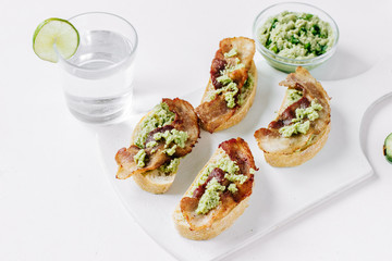 Sandwiches with bacon and guacamole sauce on a white board