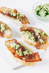 Sandwiches with bacon and guacamole sauce on a white board