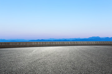 asphalt road and blue sky with white clouds by the lake © zhu difeng