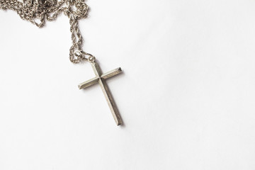 Silver cross with chain on white background