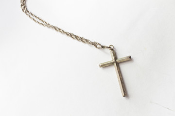 Silver cross with chain on white background
