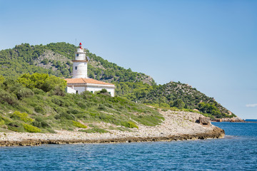 Fototapeta na wymiar Lighthouse on the small island in the sea. Mallorca, Spain
