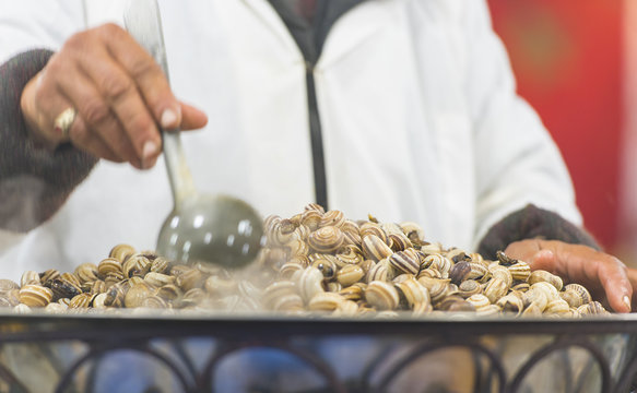Boiled snails at a street Market in Marrakech or Marrakesh Man cooking snails in Morocco 