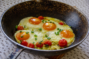 fried eggs with tomatoes in a pan