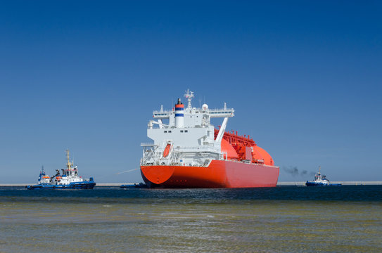 LNG TANKER - The red ship enters port with assurance of tugs