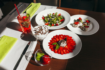 Rustic kitchen table with strawberry tiramisu, top view.  Italian food concept
