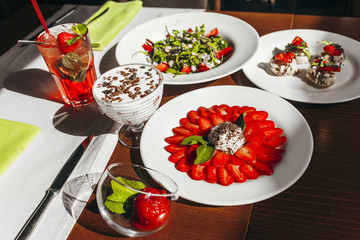Rustic kitchen table with strawberry tiramisu, top view.  Italian food concept