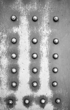Old steel plate with rivets, industrial abstract background.