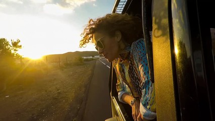 happy beautiful young woman traveling in a car across the world looking at the road and the destination. dreamer and cheerful nice female concept travel tenerife under the sun at the sunset