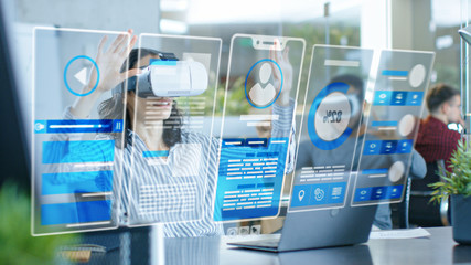 Female Virtual Reality Engineer/ Developer Wearing Virtual Reality Headset Creates Content With Her...