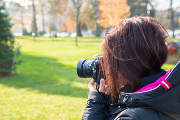 Woman Photographer Taking Pictures Outodoor on a Sunny Winter Day