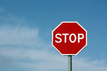 Stop sign against cloudy sky.